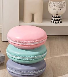 a stack of four macaroons sitting on top of each other in front of a shelf