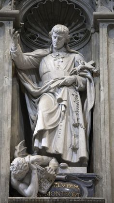 a statue of a man holding a cross in front of a building