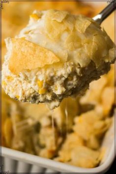 a spoonful of chicken pot pie casserole being lifted from the casserole dish