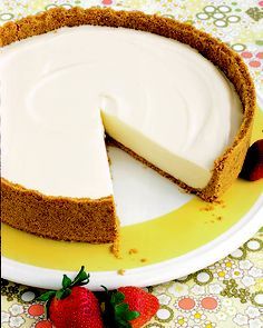 a cheesecake on a yellow plate with strawberries