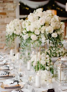 the table is set with white flowers and candles