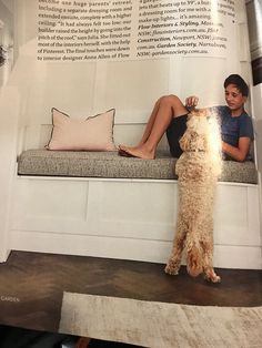 a person sitting on a bench with a dog in front of them and an article about dogs