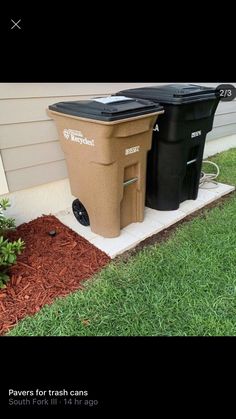 two trash cans sitting next to each other in the grass