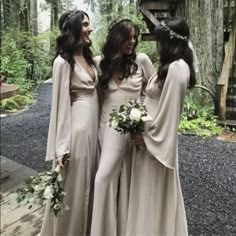 three women in long dresses standing next to each other