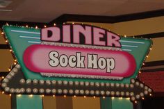 a neon sign that says dinner stockhop hanging from the ceiling