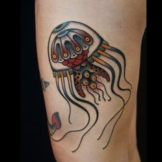 a tattoo with a jellyfish on it's leg and an anchor in the middle