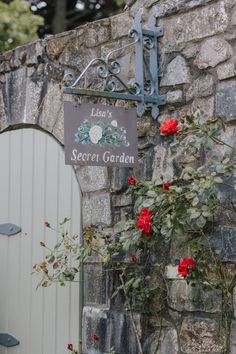 there is a sign that says secret garden on the side of a building with flowers growing out of it