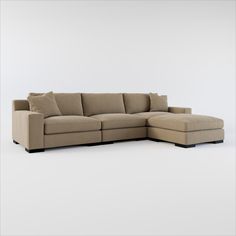 a beige sectional couch with pillows on the top and bottom corner, in front of a white background