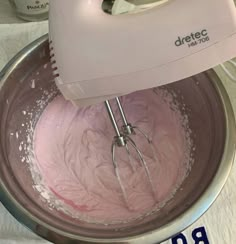 a mixer with pink icing inside of it