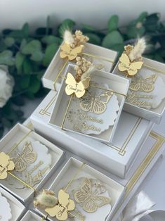 four white boxes with gold butterflies on them