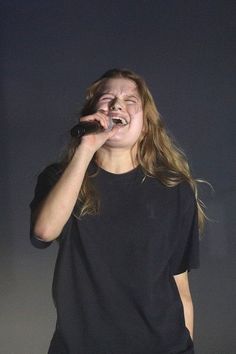 a woman singing into a microphone on stage