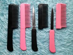 three pink and black combs sitting next to each other on top of a blue blanket