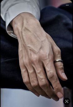 a close up of a person's hand with a ring on it