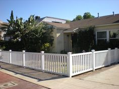 a white picket fence in front of a house