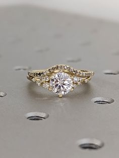 an engagement ring with three stones on top and two rows of diamonds around the band