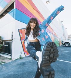 a woman is posing with her foot in the air while holding onto a skateboard