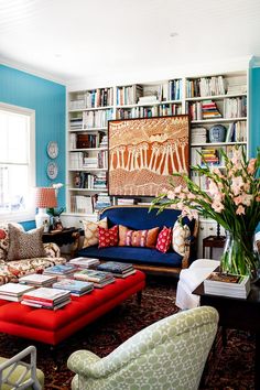 a living room filled with lots of furniture and bookshelves full of books on shelves