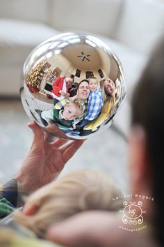 a person holding up a glass ball with pictures on it