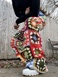 a woman standing on top of a pile of crocheted granny's pants