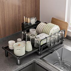 a dish rack filled with dishes next to a sink