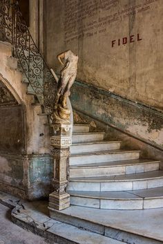 an old building with stairs and a statue