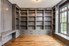 an empty walk - in closet with wooden floors and gray cabinets, lights on the ceiling