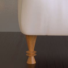 a close up of a white chair with wood legs