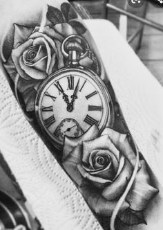 a black and white photo of a clock with roses on the side of his arm