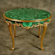 a green marble topped table with gold trimmings on the top and bottom edge