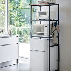 a kitchen with a sink, microwave and refrigerator in it's stand up space