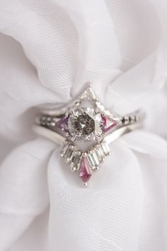 a diamond ring sitting on top of a white cloth