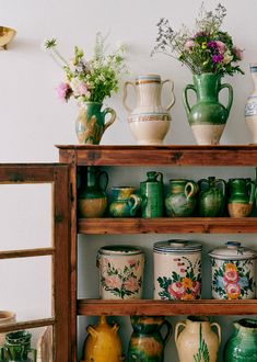 a shelf filled with lots of vases and flowers