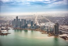 an aerial view of a large city next to a lake with snow on the ground