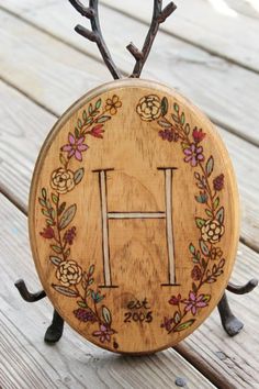 a wooden plaque with the letter h painted on it