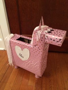 a pink box with a heart on it sitting on the floor next to a door