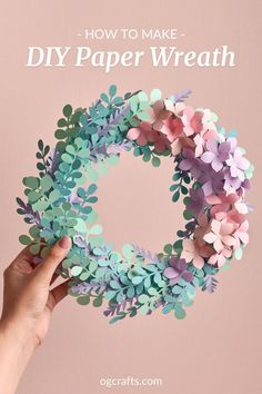 someone holding up a paper wreath with flowers on it and the words how to make diy paper wreath