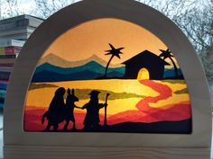 a stained glass nativity scene is displayed in front of some books on a table