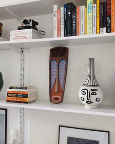 a shelf with books and vases on it