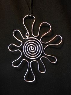 a silver pendant with spiral design on it