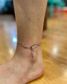 a woman's foot with a small tattoo on the side of her left ankle