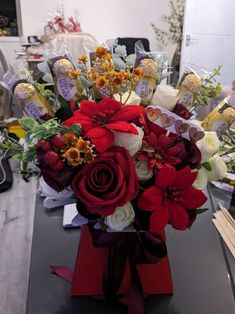 a vase filled with red and white flowers sitting on top of a table next to books