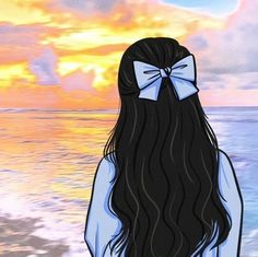 a woman with long black hair and a bow on her head standing in front of the ocean