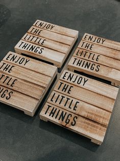 four wooden signs that say enjoy the little things