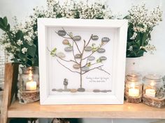 a framed family tree with rocks and candles