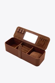 an open brown case with two compartments and a mirror in the top one is empty