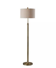 a floor lamp with a beige shade on it's side and a white background