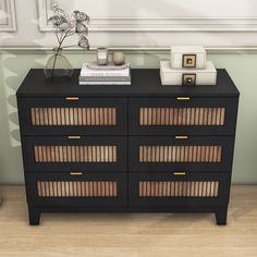 a black dresser with books and vases on top