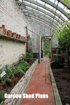 the inside of a greenhouse with plants growing in pots on shelves and brick flooring