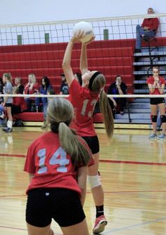 two girls are playing volleyball on the court