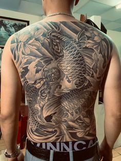 the back of a man with tattoos on his body